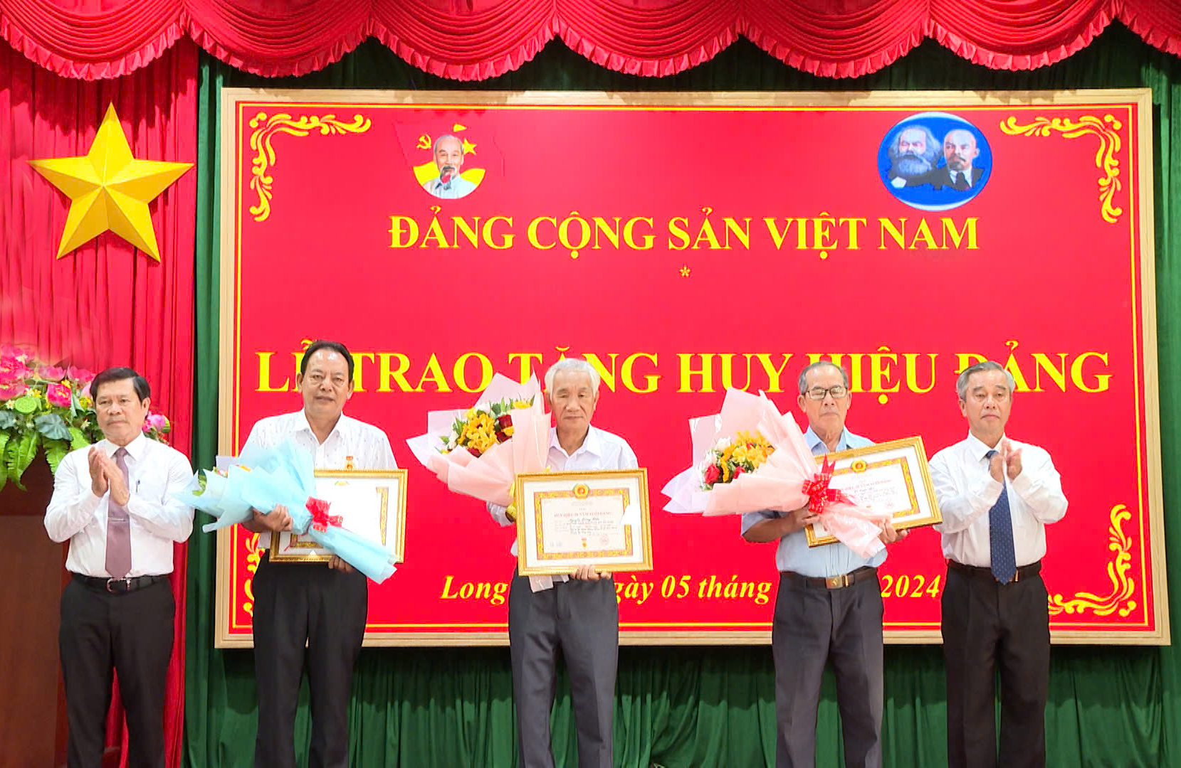 Ông Nguyễn Văn Xinh, Trưởng Ban Tuyên giáo Tỉnh ủy; ông Võ Hữu Hạnh,  Phó Bí thư Thường trực Huyện ủy Long Điền trao Huy hiệu Đảng tới các đảng viên.
