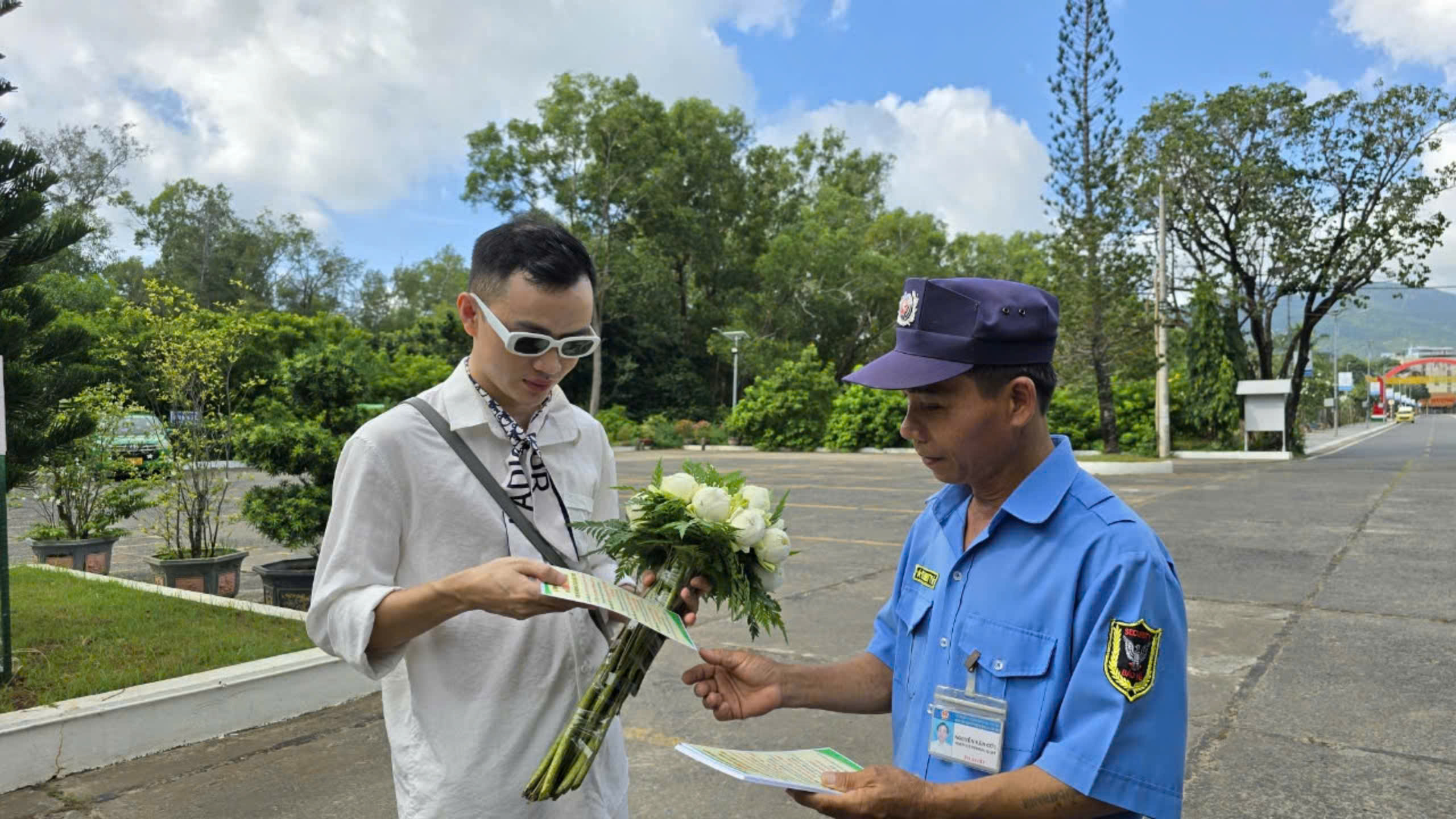 Nhân viên bảo vệ Nghĩa trang Hàng Dương phát tờ rơi hướng dẫn khách thực hiện quy định Giỏ lễ xanh.