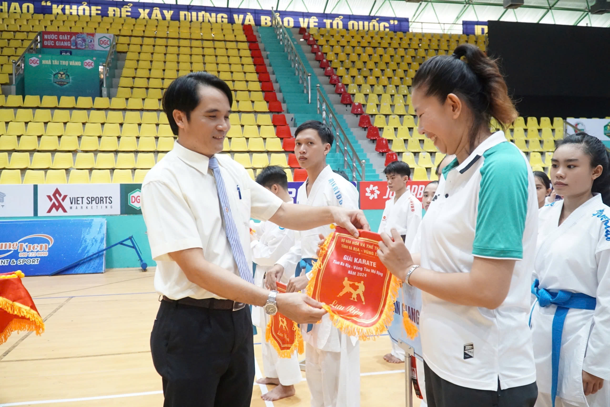 Ông Nguyễn Thanh Phong, Phó Giám đốc phụ trách Trung tâm Huấn luyện và thi đấu TDTT tỉnh trao cờ lưu niệm cho các đoàn. 