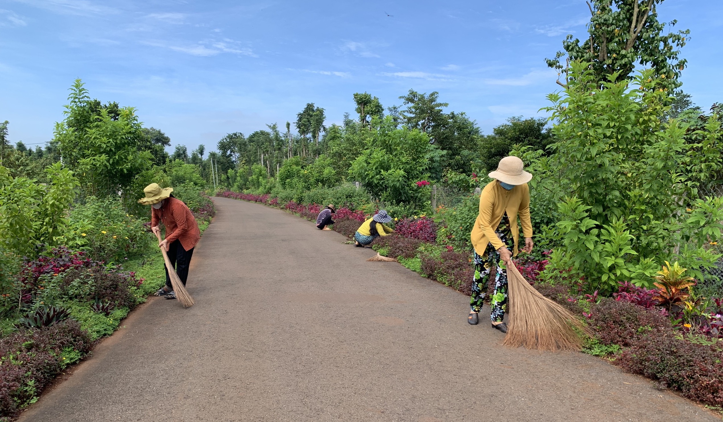 Người dân xã Kim Long cắt tỉa hoa, quét dọn đường làng chào mừng  lễ kỷ niệm 60 năm Chiến thắng Bình Giã.