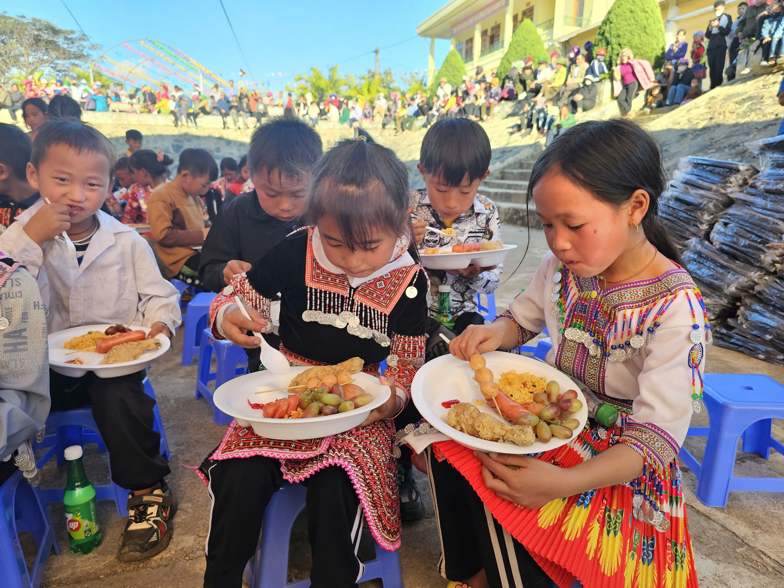 Trẻ em dân tộc thiểu số xã Ngọc Chiến, huyện Mường La, tỉnh Sơn La thích thú thưởng thức ẩm thực tại phiên chợ.