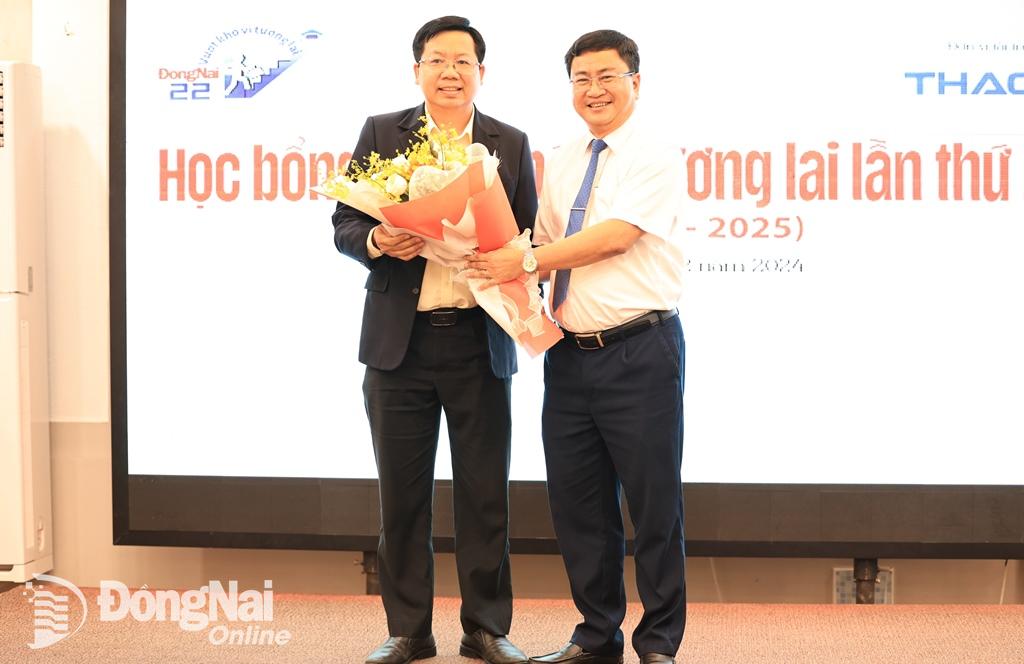 Tổng biên tập Báo Đồng Nai Đào Văn Tuấn trao hoa cảm ơn đại diện Công ty CP Tập đoàn Trường Hải đã tiếp tục đồng hành với chương trình học bổng Vượt khó vì tương lai. Ảnh: Công Nghĩa