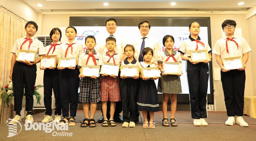 Phó chủ tịch UBND tỉnh Nguyễn Sơn Hùng và Tổng biên tập Báo Đồng Nai Đào Văn Tuấn trao học bổng cho các em học sinh đơn vị thành phố Biên Hòa. Ảnh: Công Nghĩa