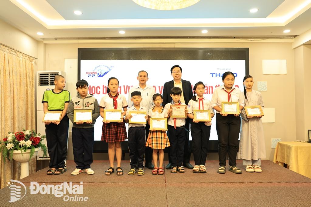 Phó trưởng ban Tuyên giáo Tỉnh ủy Phạm Tấn Linh cũng đại diện Công ty CP Tập đoàn Trường Hải trao quà cho các em học sinh. Ảnh: Công Nghĩa