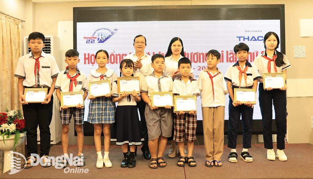 Phó tổng biên tập Báo Đồng Nai Hoàng Thị Bích Phú và Phó chủ tịch thường trực Hội Nhà báo tỉnh Hồ Văn Chừng trao học bổng cho các em học sinh. Ảnh: Công Nghĩa