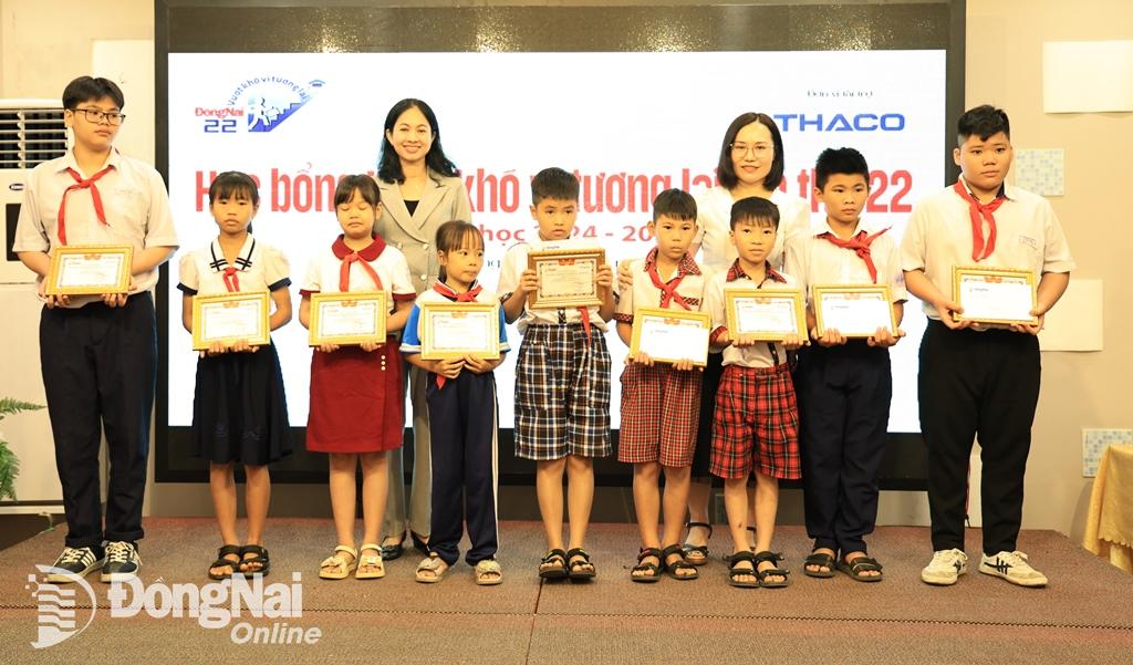 Trưởng ban Chính trị, Văn hóa - xã hội Báo Đồng Nai Nguyễn Thị Phượng và Phó trưởng phòng Giáo dục và đào tạo thành phố Biên Hòa Lưu Thi Hằng trao học bổng cho các em học sinh. Ảnh: Công Nghĩa