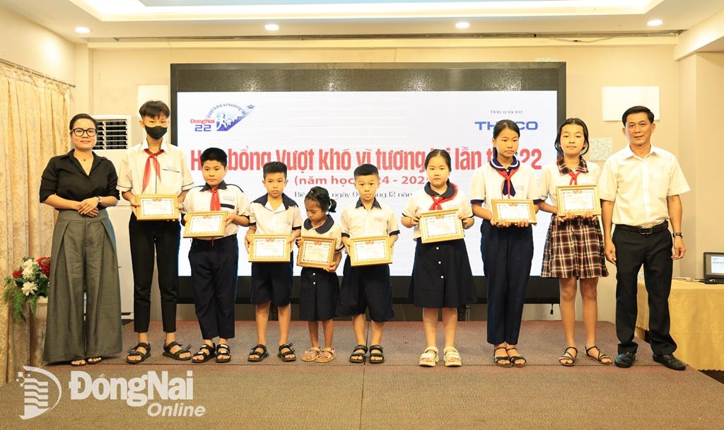 Trưởng phòng Điện tử Báo Đồng Nai Phan Thị Kim Ngân và Phụ trách phòng Hành chính Báo Đồng Nai Phạm Nguyễn Anh Tú trao học bổng cho các học sinh. Ảnh: Công Nghĩa