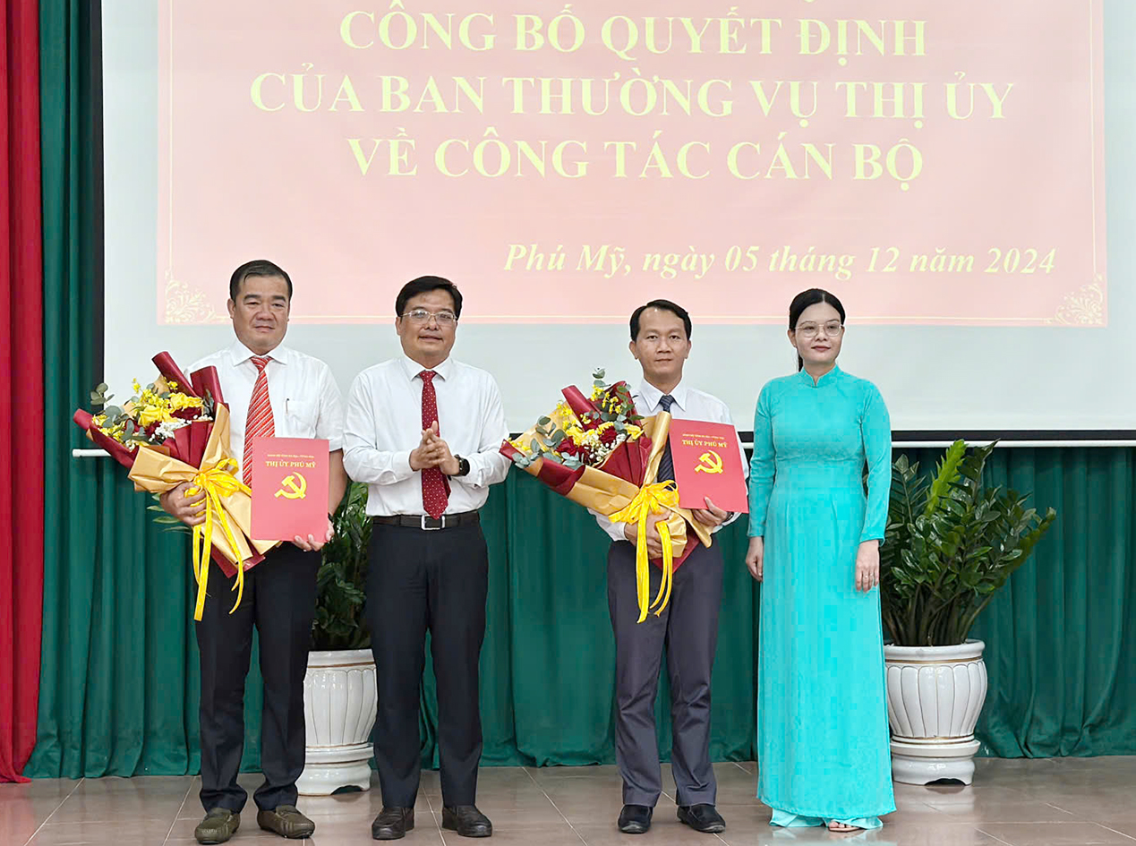 Ông Nguyễn Tấn Cường, Phó Bí thư Thường trực và bà Nguyễn Thị Ngọc Phượng, Trưởng Ban Tổ chức Thị ủy Phú Mỹ trao quyết định và tặng hoa chúc mừng 2 cá nhân.