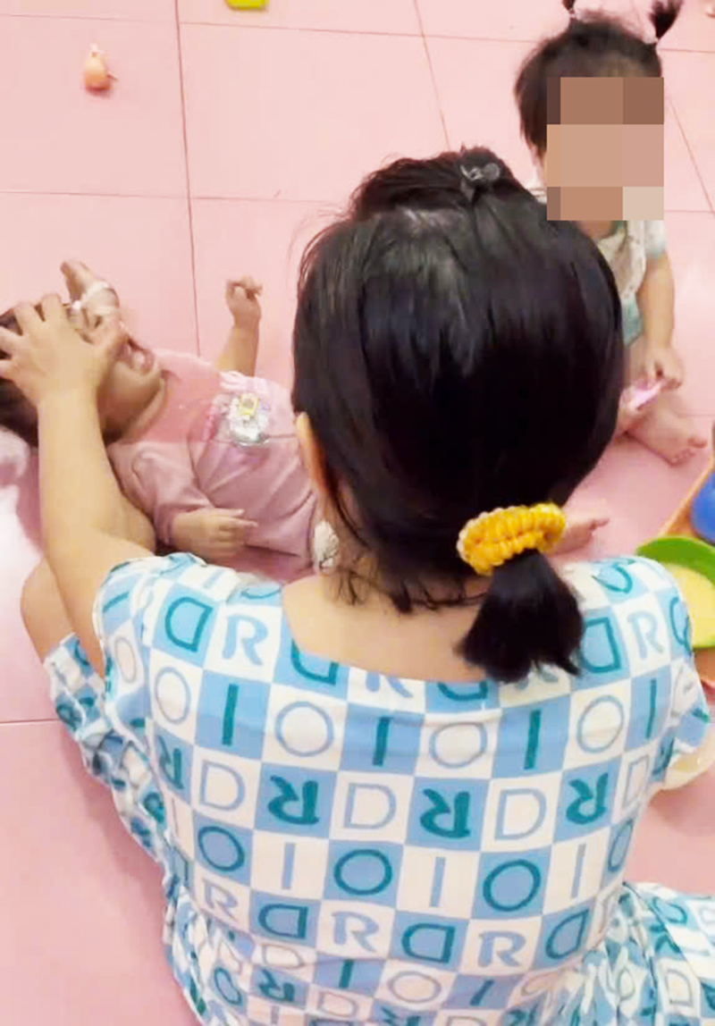 Bà B. dùng tay nắm tóc một bé hơn 1 tuổi, giật ra sau, tay còn lại liên tục dùng thìa đút thức ăn với hành động thô bạo.