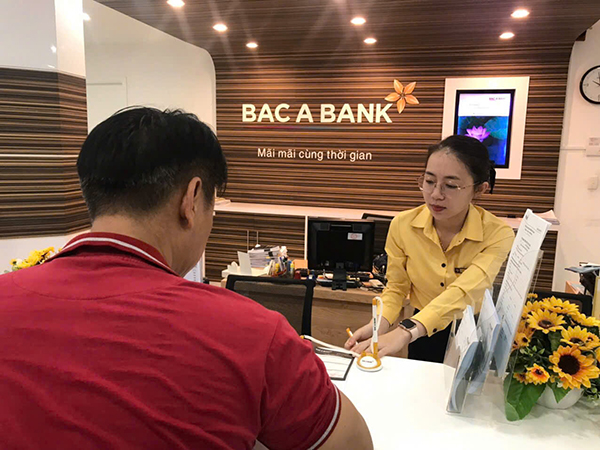 Nhân viên Bắc Á Bank hỗ trợ khách hàng cập nhật sinh trắc học tại quầy.