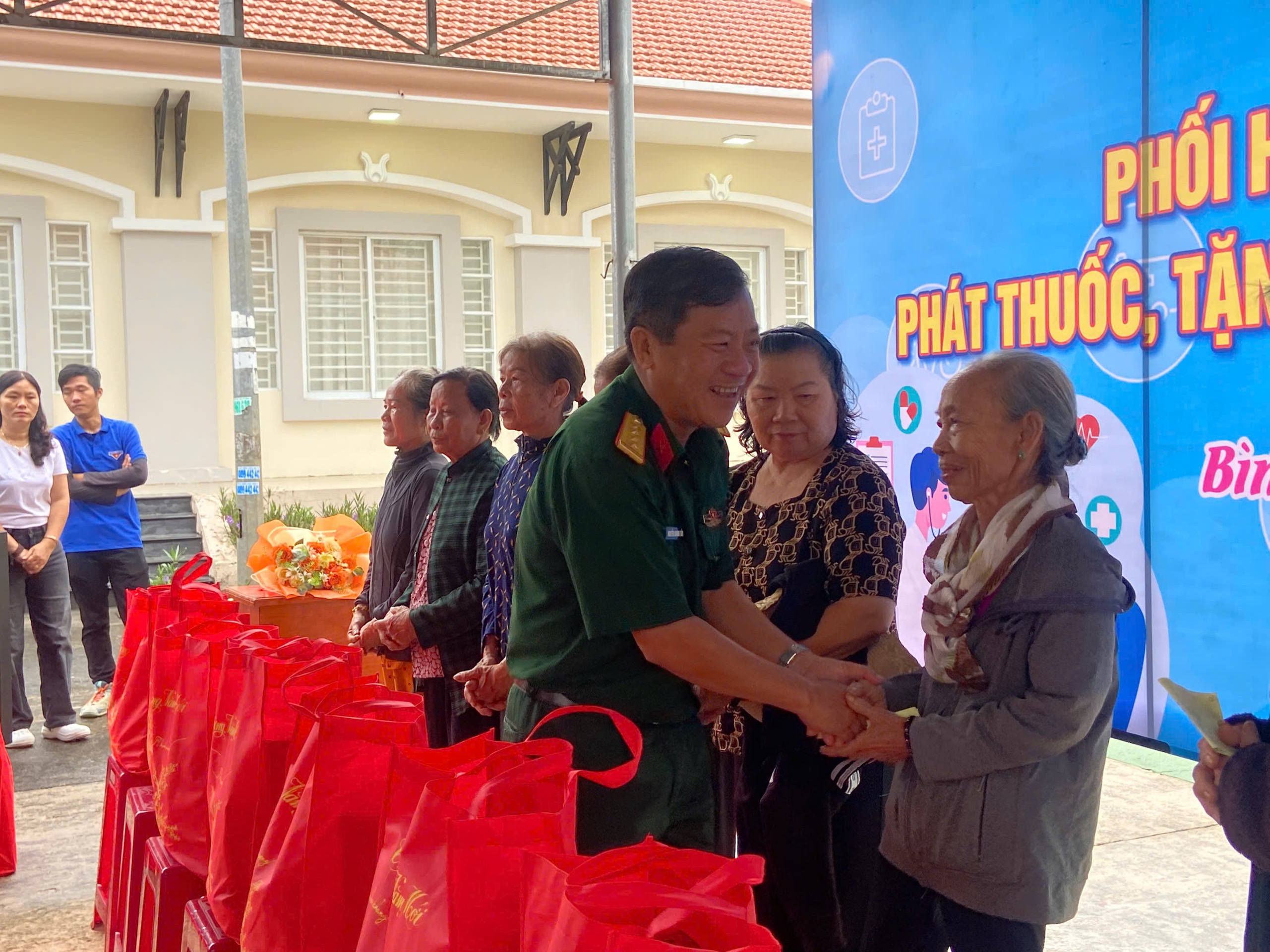 Đại tá Nguyễn Hoàng Tấn, Phó Chính ủy Bộ CHQS tỉnh trao quà cho các gia đình khó khăn  tại buổi khám bệnh, phát thuốc miễn phí.