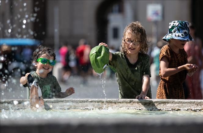 Trẻ em làm mát bên đài phun nước trong ngày nắng nóng ở Rome, Italy.