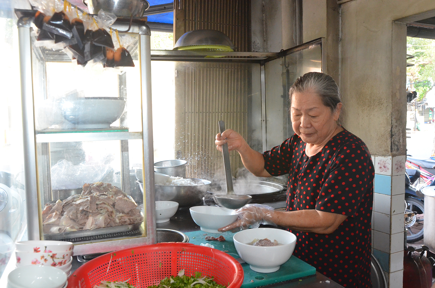 Bà Bùi Thị Nhung, 72 tuổi, chuẩn bị những tô phở thơm ngon  phục vụ khách.