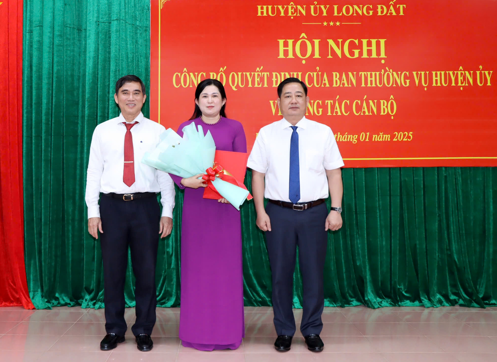 Ông Trần Thượng Chí, Bí thư Huyện ủy Long Đất và ông Trần Thanh Hùng, Phó bí thư Thường trực Huyện ủy Long Đất trao quyết định và tặng hoa cho bà Mã Lê Phương Thảo. Ảnh: TUẤN VŨ