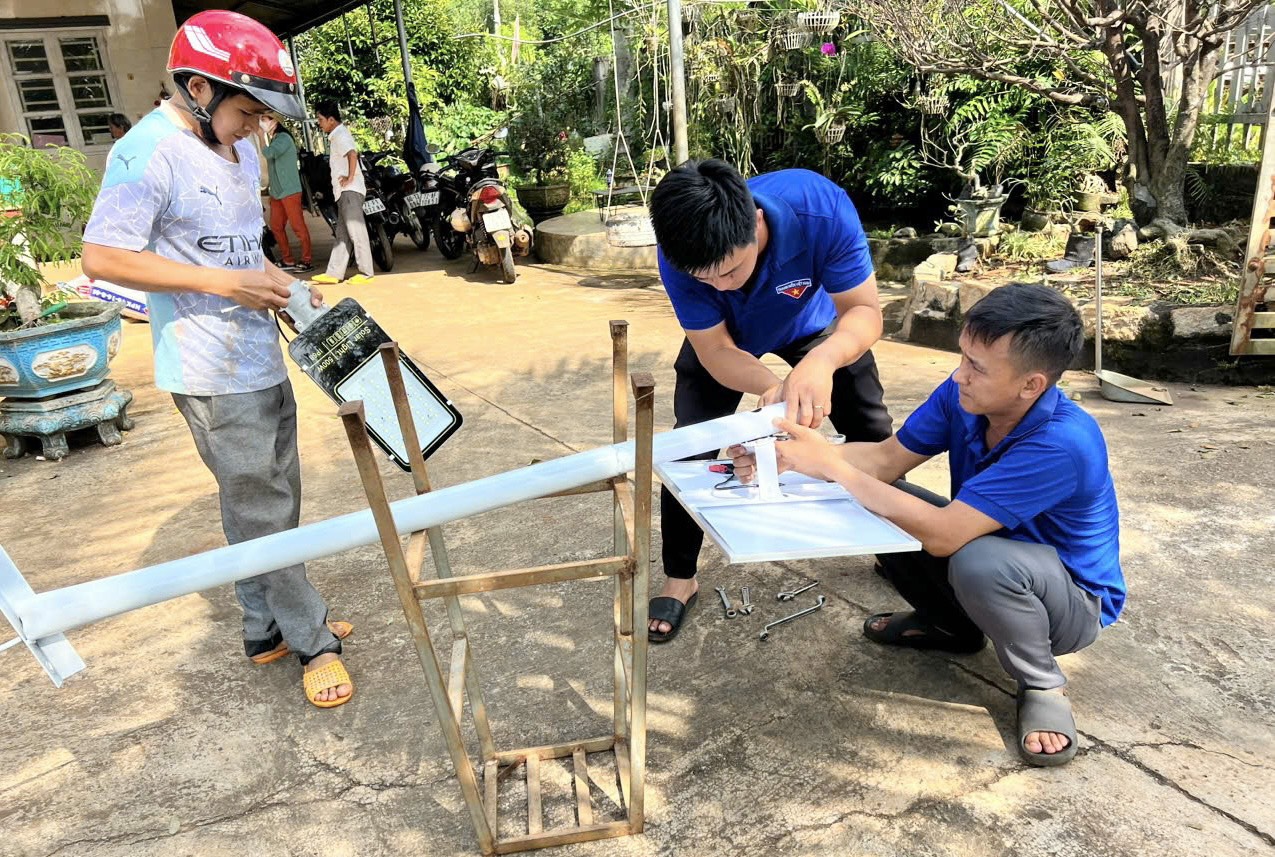 Các đoàn viên lắp đặt đèn năng lượng mặt trời.