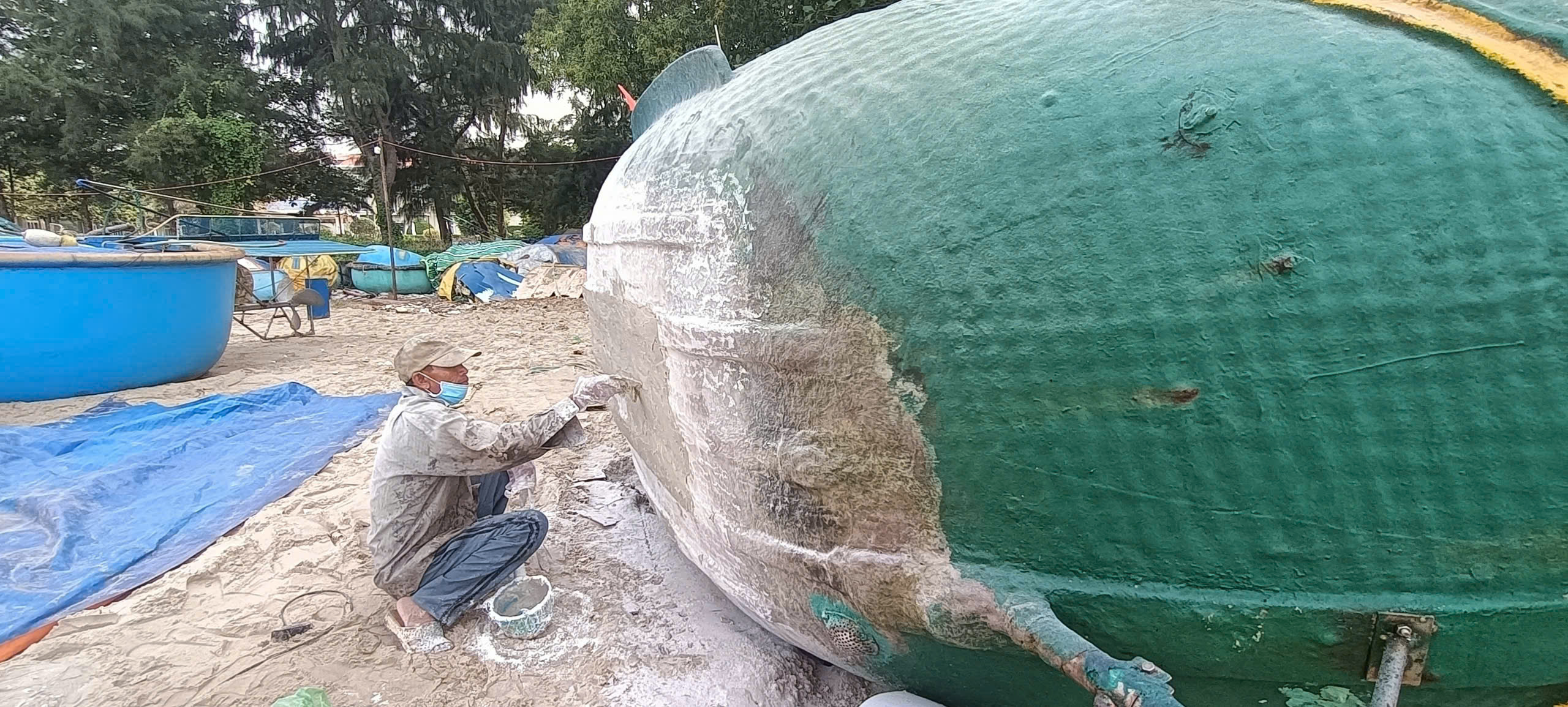Một vài ngư dân đã nghỉ Tết sơn phết, gia cố lại 2 bên mạn thuyền bị sóng đánh mòn.