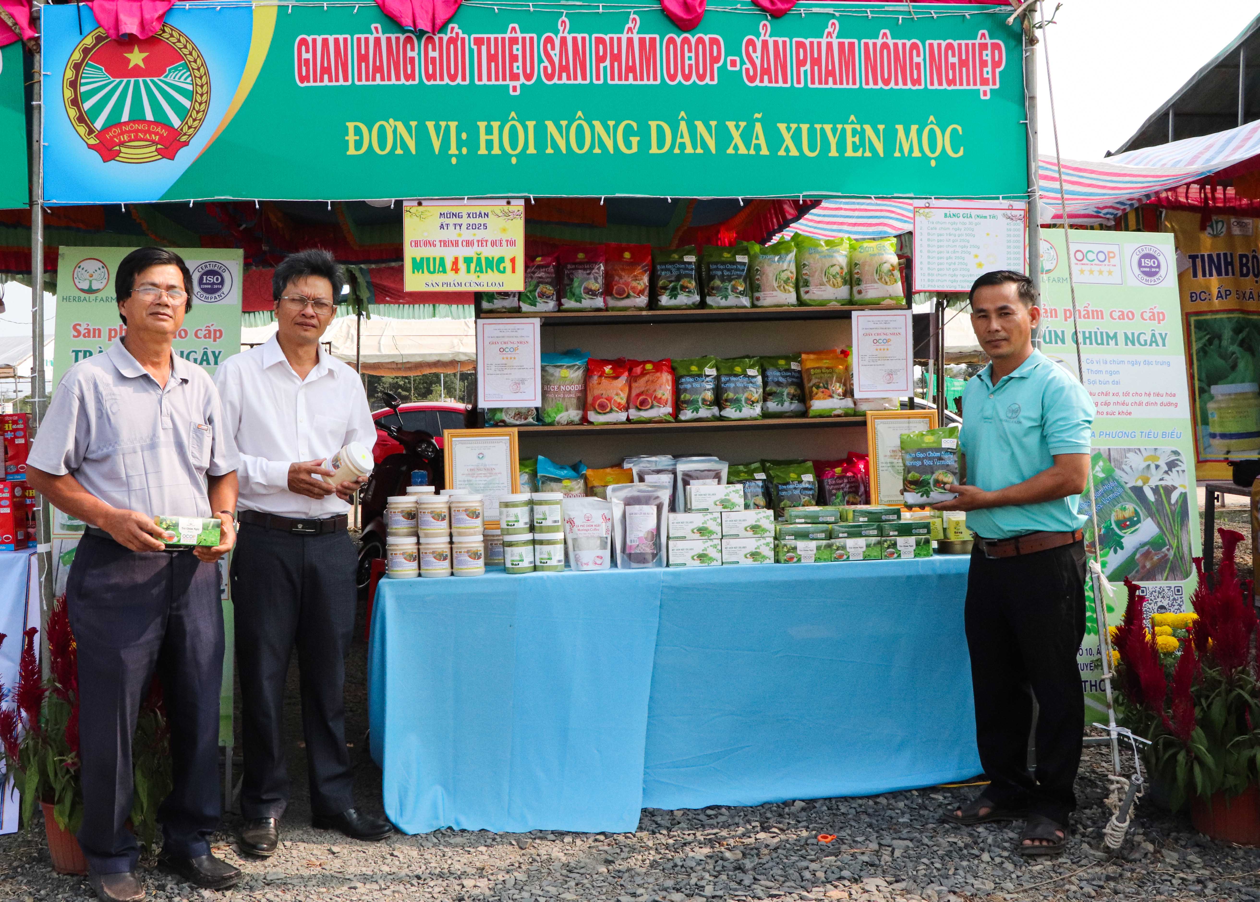 Ông Dương Tấn Linh (thứ hai từ trái qua), Chủ tịch Hội Nông dân huyện Xuyên Mộc tham quan gian hàng xã Xuyên Mộc, với các sản phẩm chế biến từ cây chùm ngây, đạt OCOP 4 sao.