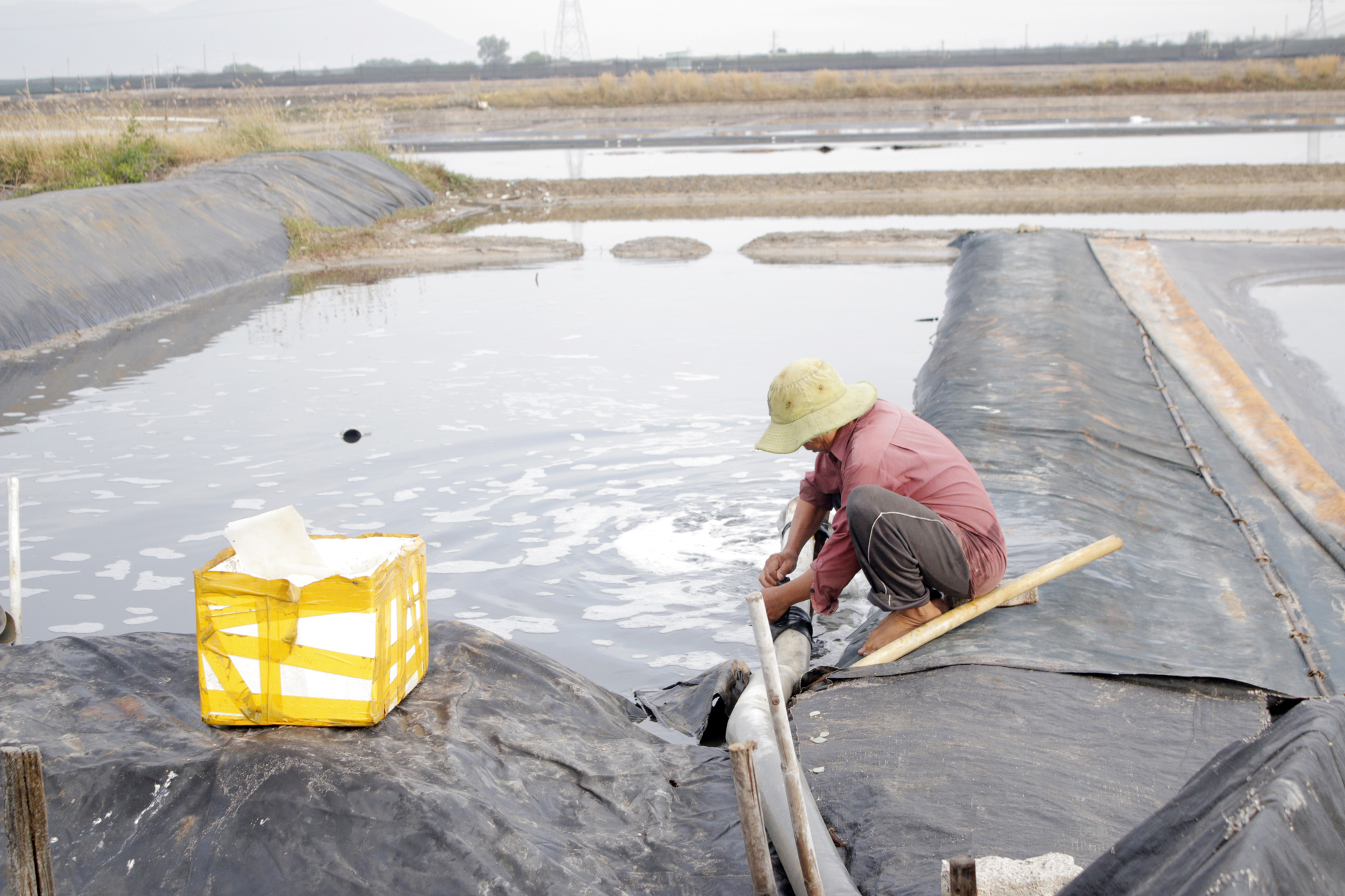 Ông Nguyễn Văn Hùng (xã Tam An, huyện Long Đất) tháo nước từ các ô muối để kiểm tra bạt, chuẩn bị cho vụ muối mới.