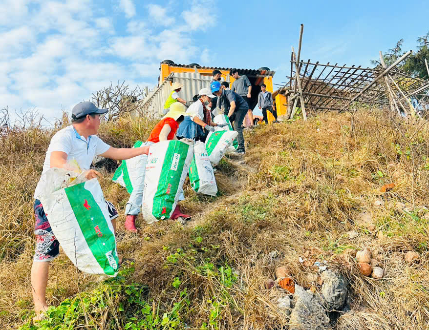 Các thành viên trong CLB Hành trình xanh và một số khách du lịch tham gia thu gom rác tại mũi Nghinh Phong, TP. Vũng Tàu