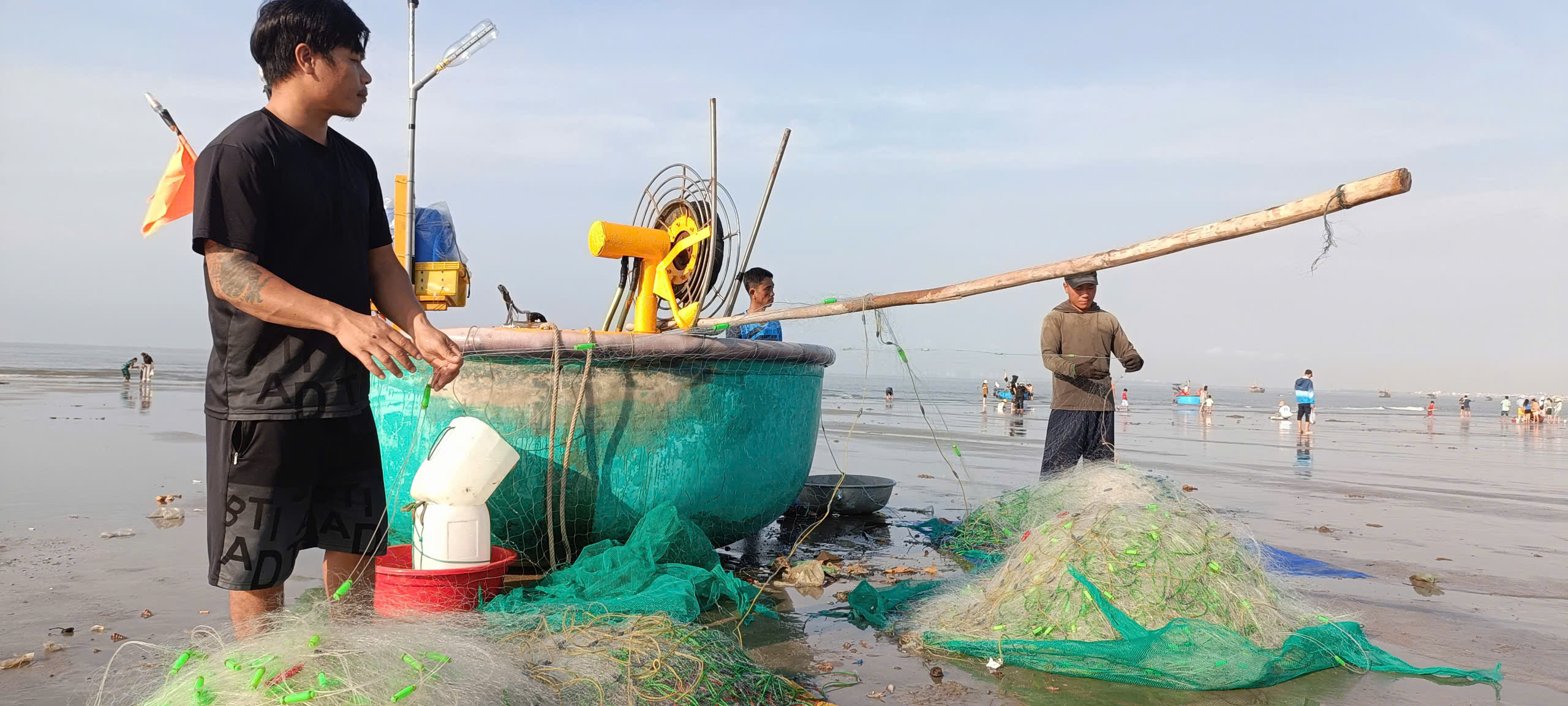 Ngu dân thu lưới sau khi đã bán cá, ghẹ cho thương lái.