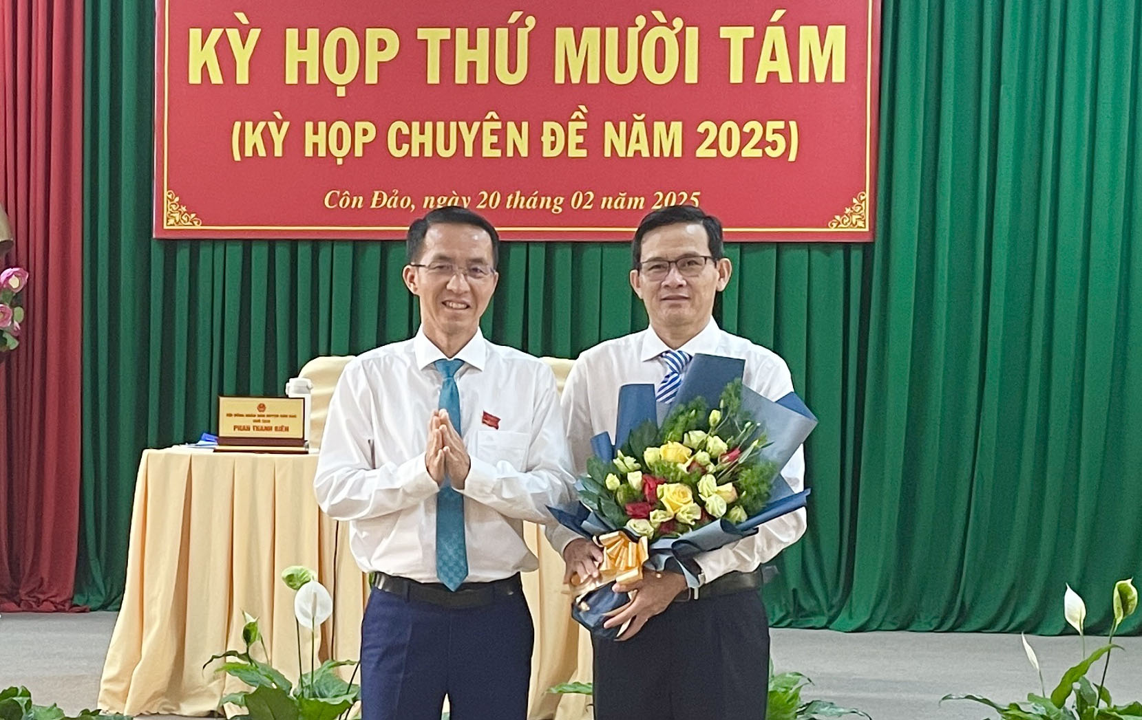 Ông Phan Thanh Biên, Phó Bí thư Thường trực Huyện ủy, Chủ tịch HĐND huyện Côn Đảo (bên trái) tặng hoa chúc mừng ông Phan Trọng Hiền.