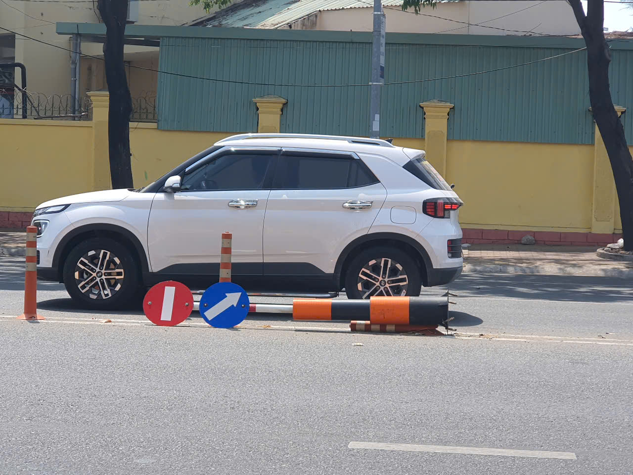 Cột biển báo giao thông đổ nằm giữa đường