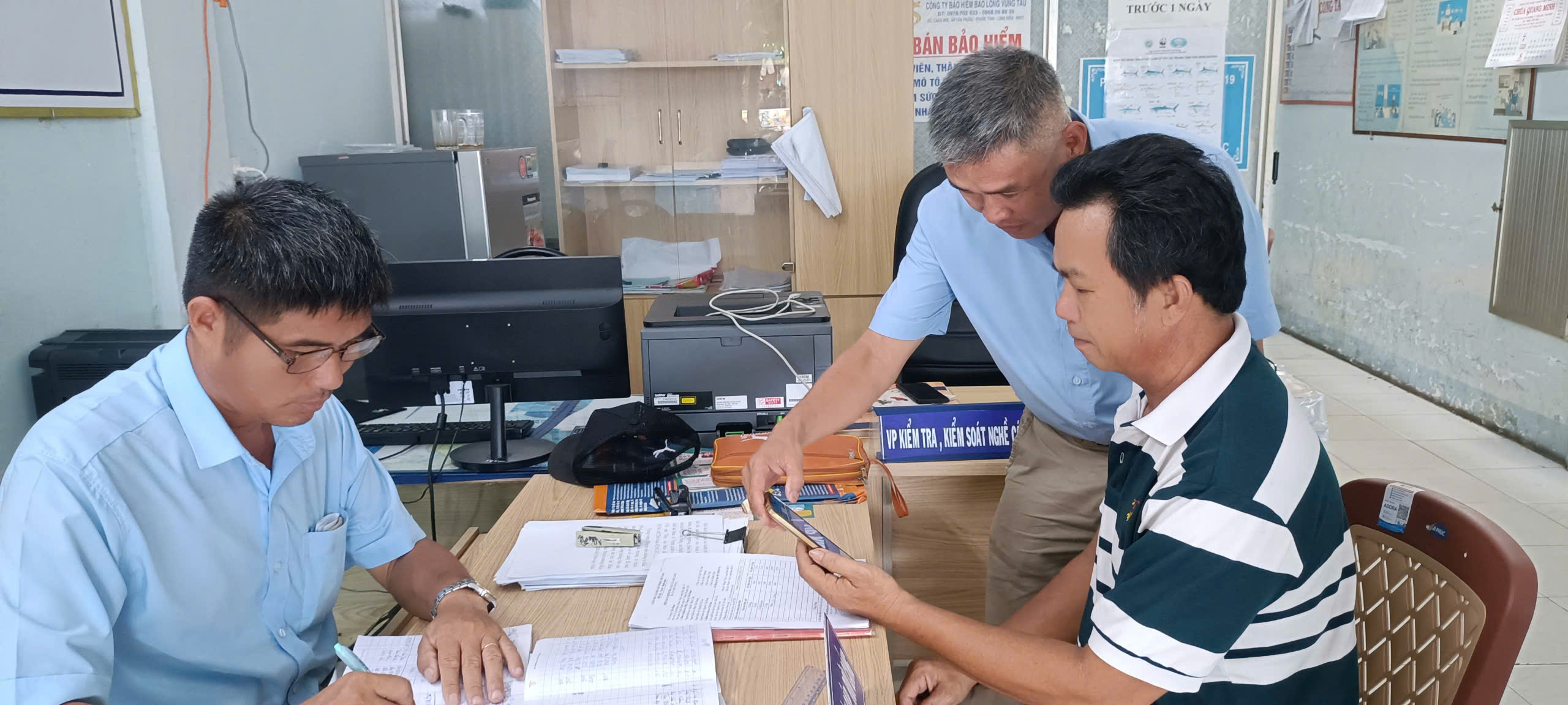 Nhân viên Cảng cá Tân Phước (huyện Long Đất) hướng dẫn ngư dân khai báo thông tin xuất, nhập cảng, ghi nhật ký kai thác điện tử.