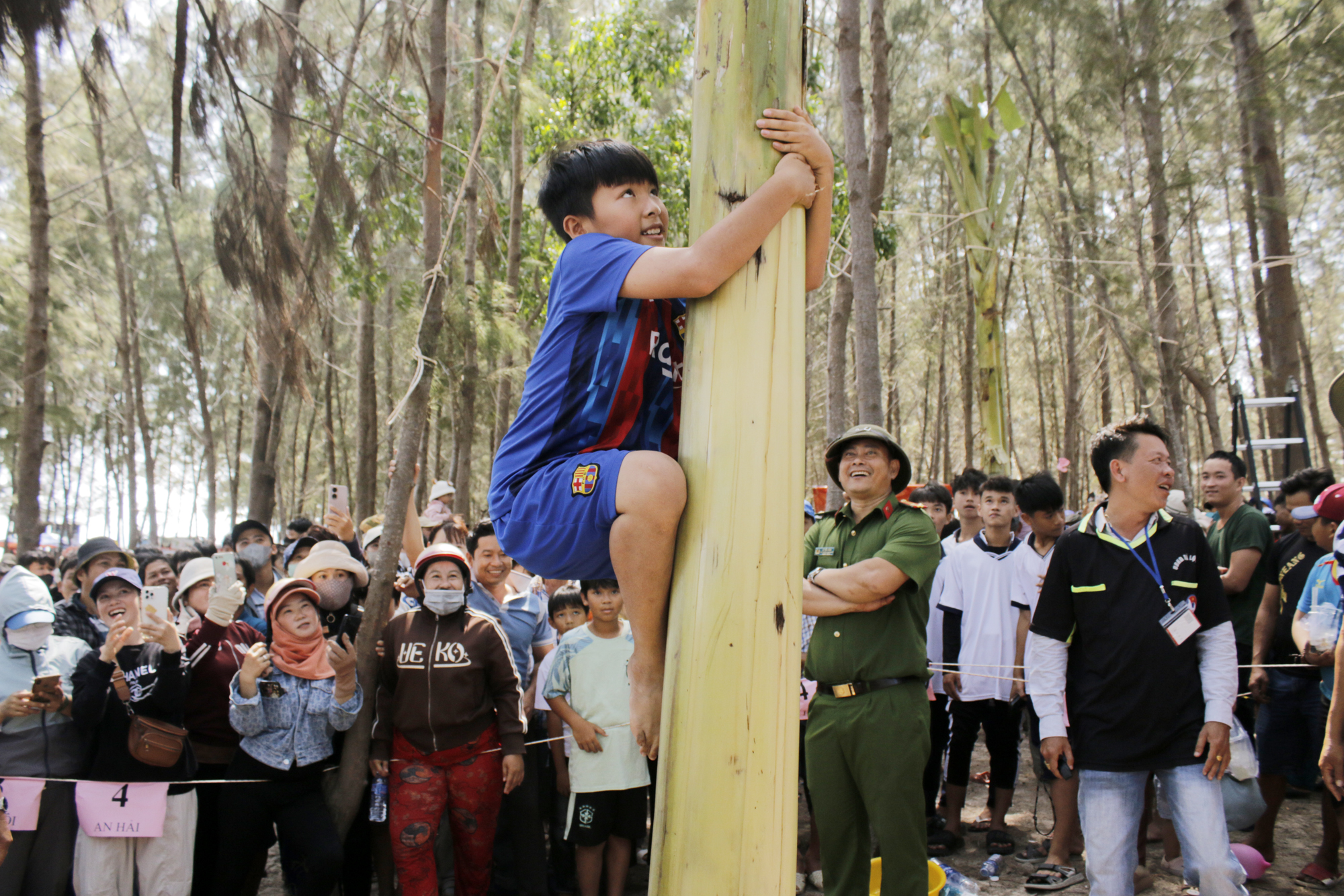 Người dân tham gia trò chơi trèo cây chuối.