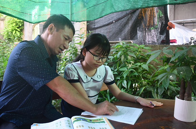 Ông Phạm Xuân Ngọ, hội viên Hội Nông dân xã Sông Xoài (TP.Phú Mỹ) là thành viên lớn tuổi gương mẫu của CLB “Làm cha trách nhiệm” xã Sông Xoài, TP.Phú Mỹ. Trong ảnh: Ông Phạm Xuân Ngọ hướng dẫn con gái học bài.