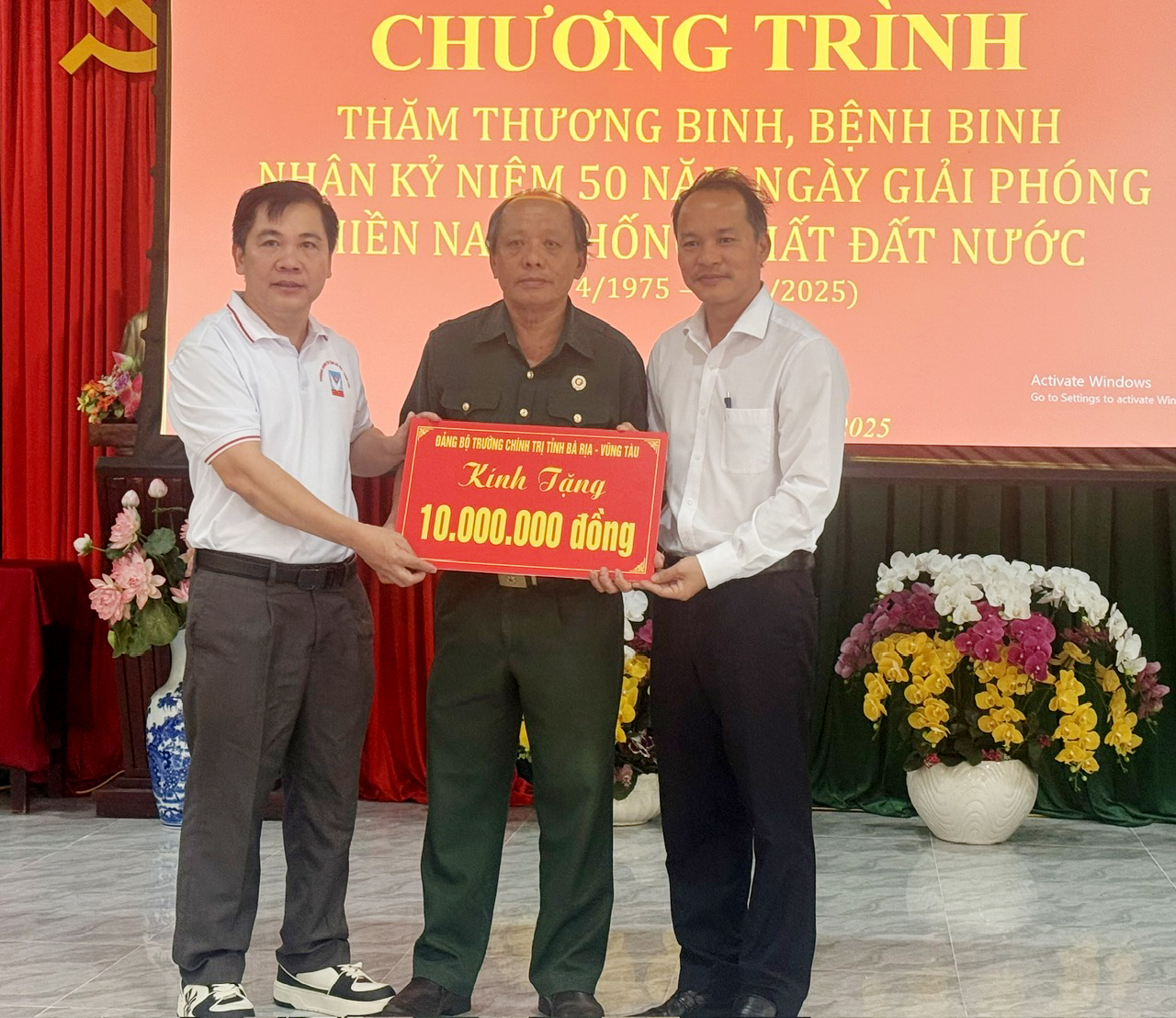 Thạc sĩ Nguyễn Văn Thắng, Hiệu trưởng Trường Chính trị tỉnh (bìa trái) tặng quà cho Trung tâm Điều dưỡng thương binh và người có công Long Đất.
