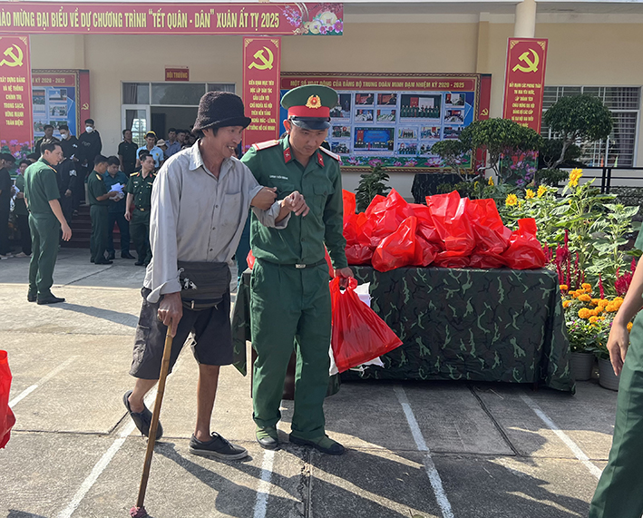Hỗ trợ người dân nhận quà tại chương trình “Tết quân dân” do Bộ CHQS tỉnh tổ chức.