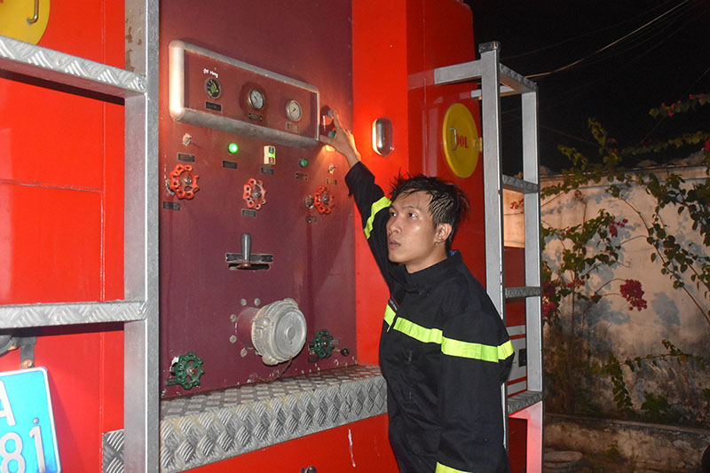 Một chiến sĩ điều chỉnh áp lực nước tại xe chữa cháy. 