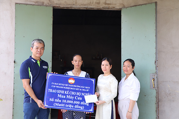Đại diện MTTQ và CLB “Doanh nghiệp đoàn kết và chia sẻ” trao vốn mua máy cưa tới chị Trần Thị Lan.