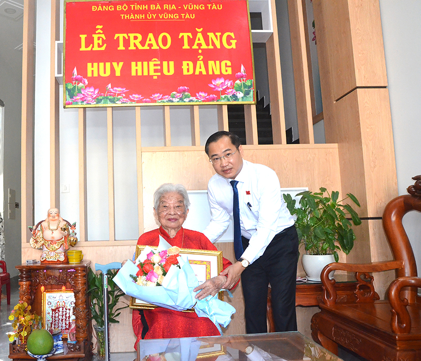Ông Lê Xuân Tú, Trưởng Ban Tuyên giáo và Dân vận Thành ủy Vũng Tàu trao Huy hiệu Đảng cho đảng viên bà Hồ Thị Lưu (Chi bộ 6, Đảng bộ phường 4).