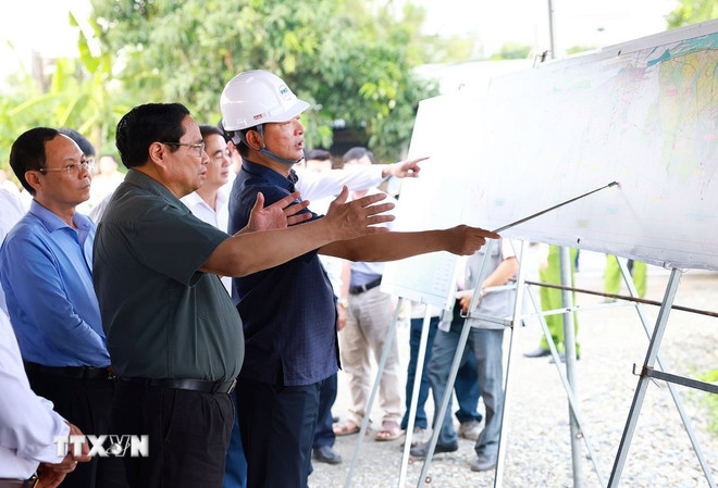 Thủ tướng Phạm Minh Chính nghe báo cáo tiến độ thi công tuyến đường cao tốc Châu Đốc - Cần Thơ-Sóc Trăng, đoạn đi qua xã Đông Thắng, huyện Cờ Đỏ. (Ảnh: Dương Giang/TTXVN)