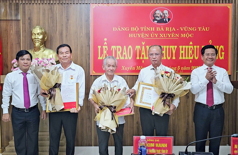 Ông Bùi Chí Thành, Trưởng Ban Tuyên giáo và Dân vận Tỉnh ủy cùng lãnh đạo Huyện ủy Xuyên Mộc trao các quyết định tặng huy hiệu Đảng cho các đảng viên.