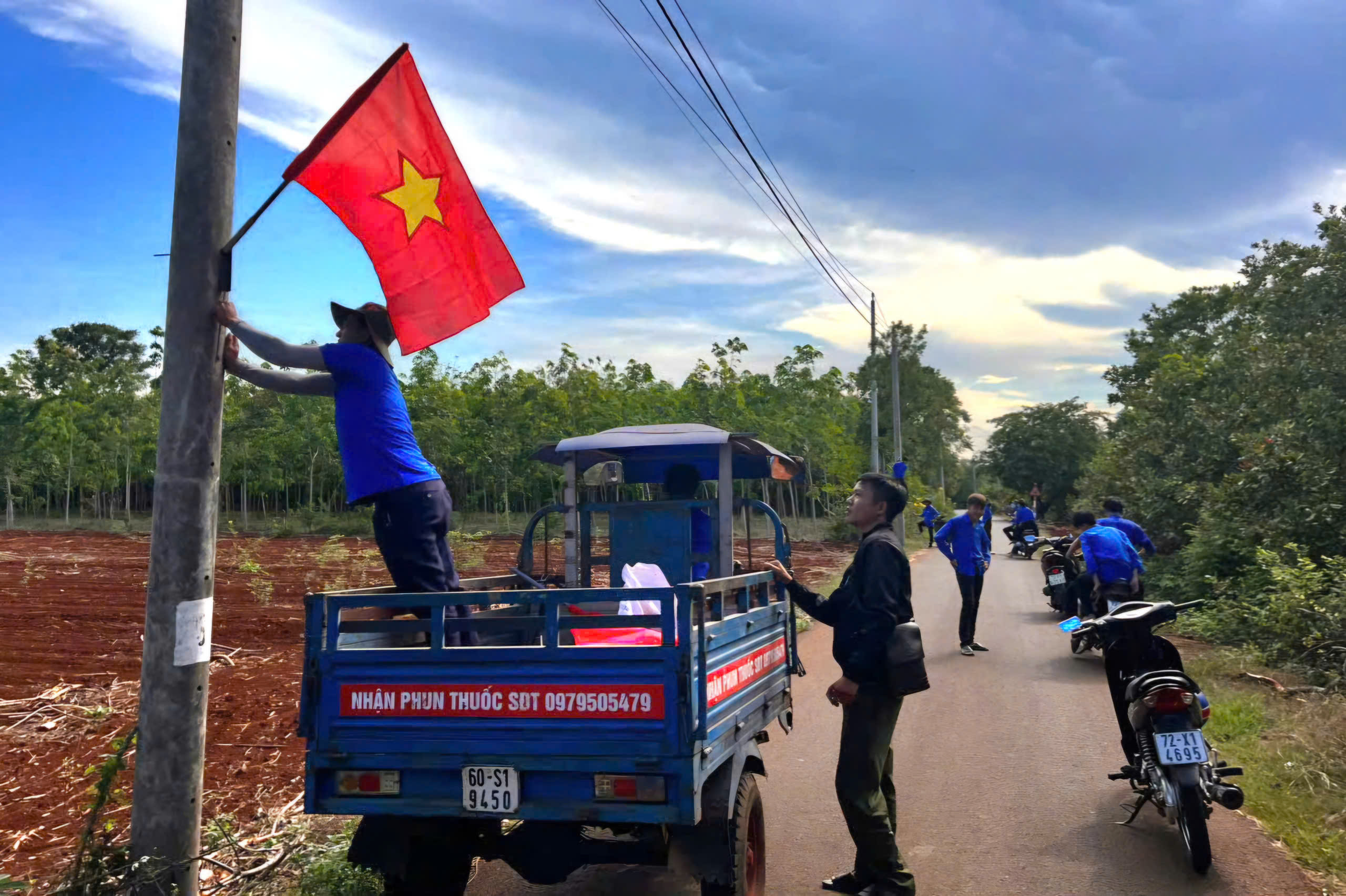 Đoàn viên thanh niên xã Láng Lớn cùng, Chi đoàn, Ban điều hành thôn Tân Giao treo cờ tổ quốc thực hiện tuyến đường cờ.