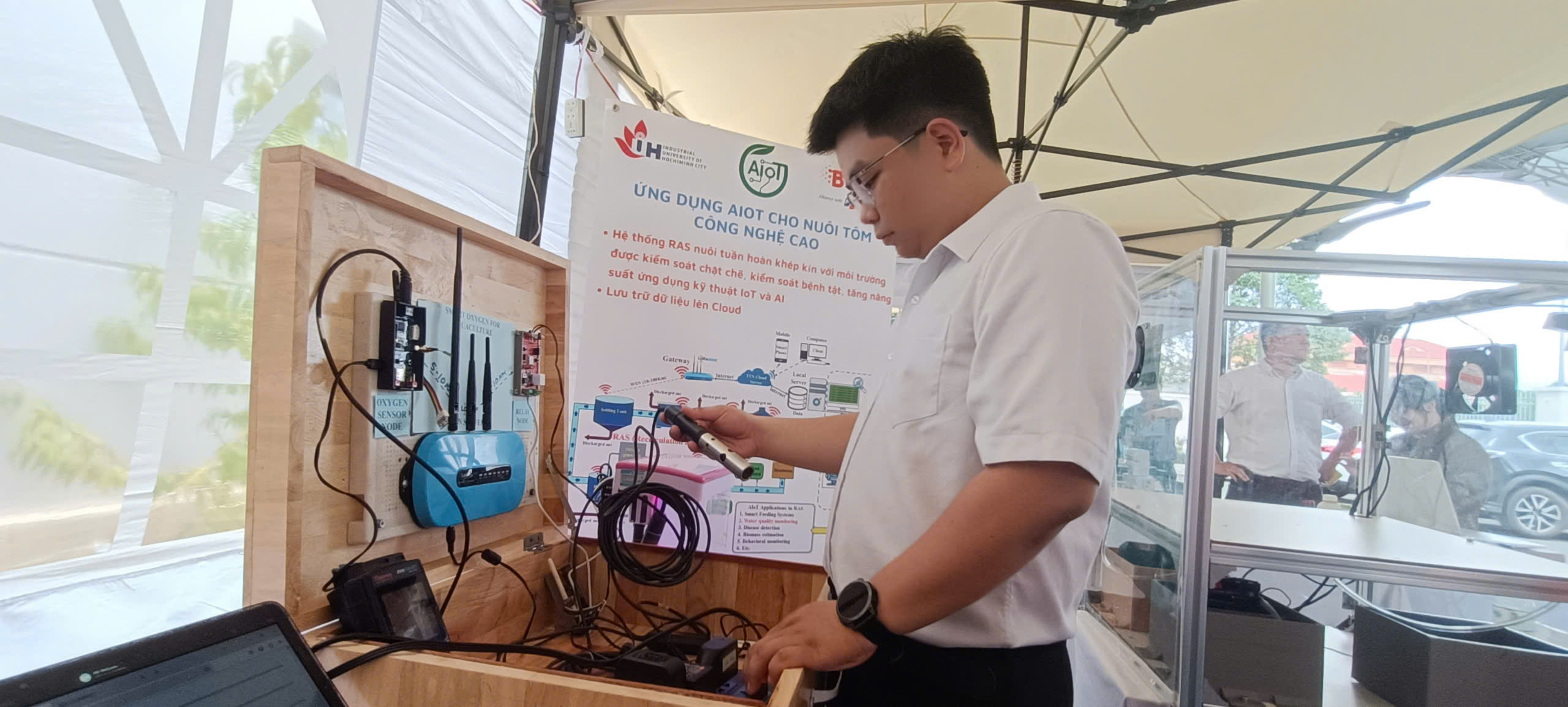 Thành viên nhóm nghiên cứu dự án Green AIoT kiểm tra thiết bị cảm biến đo nồng độ oxy trong ao nuôi tôm.