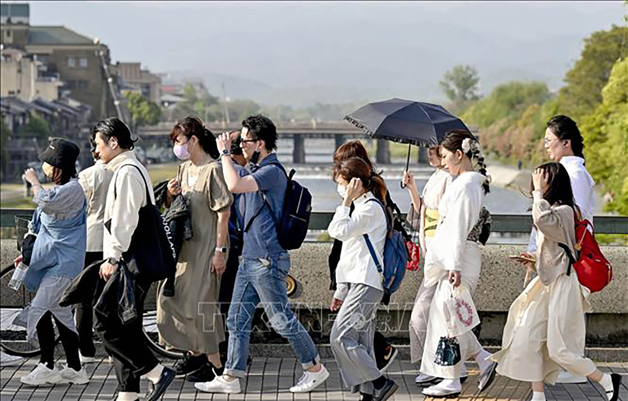 Người dân di chuyển trên đường phố dưới trời nắng nóng ở Kyoto, Nhật Bản.