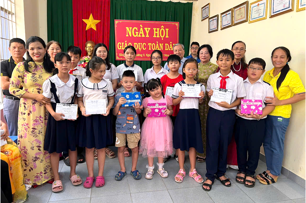 Bà Đỗ Thị Thùy Linh, Bí thư Chi bộ kiêm Trưởng ban điều hành khu phố 2, phường 3, TP.Vũng Tàu  (hàng đầu, bìa trái) tặng quà cho học sinh khó khăn của khu phố.