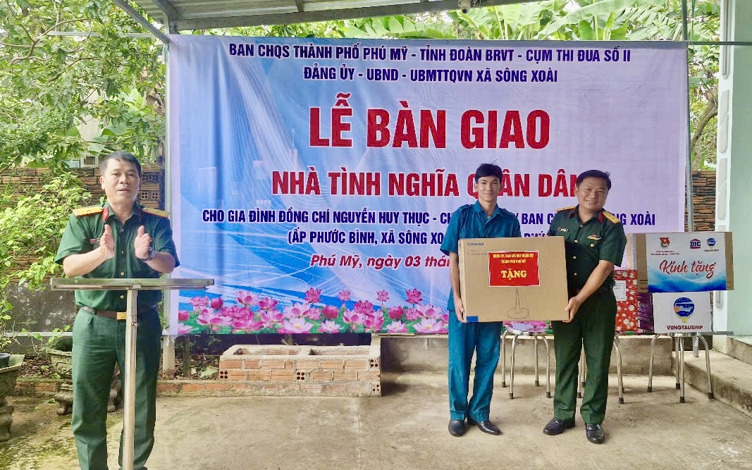 Đại diện Ban CHQS TP. Phú Mỹ tặng quà cho gia đình ông Nguyễn Huy Thục, Dân quân thường trực Ban CHQS xã Sông Xoài tại lễ bàn giao.