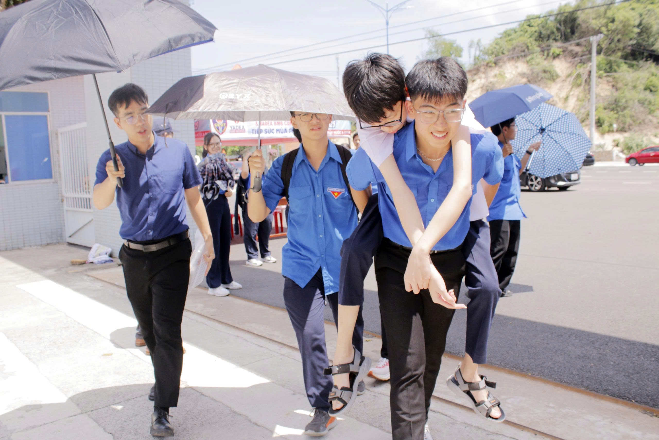 Tình nguyện viên tại điểm thi trường THPT Chuyên Lê Quý Đôn, TP. Vũng Tàu hỗ trợ cõng thí sinh Phan Quang Hào khó khăn khi di chuyển vào phòng thi. Ảnh: ĐÔNG HIẾU