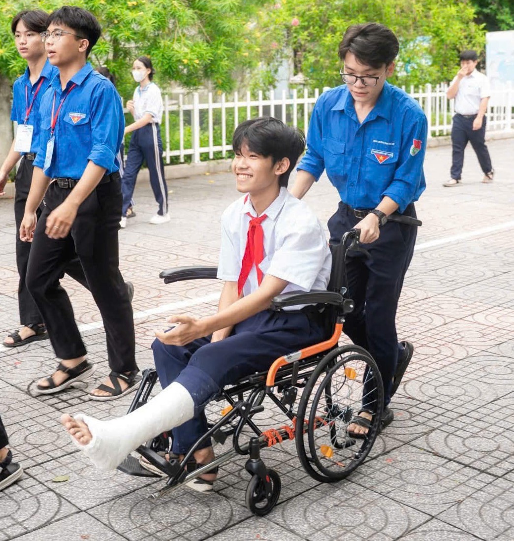 Em Nguyễn Đình Tùng được các thành viên trong đội hình tình nguyện đưa vào tận phòng thi.