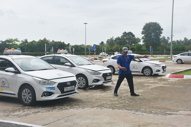 Nhân viên Trung tâm Giáo dục nghề nghiệp và sát hạch lái xe Đặng Lâm hướng dẫn học viên đưa xe vào vị trí xuất phát. 