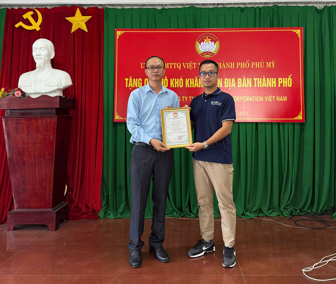 Đại diện UBMTTQ Việt Nam TP.Phú Mỹ trao thư cảm ơn cho ông Nguyễn Anh Tú, Trợ lý Trưởng phòng Hành chính Công ty TNHH Zinc Oxide Corporation Việt Nam (bìa phải).