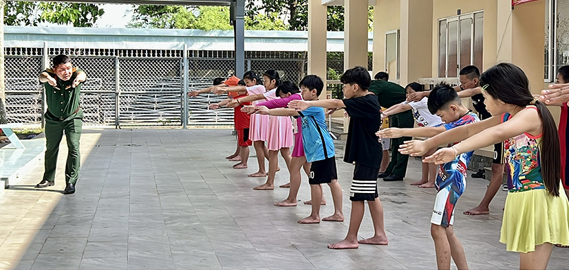 Học sinh được hướng dẫn khởi động trước khi bước vào bơi.
