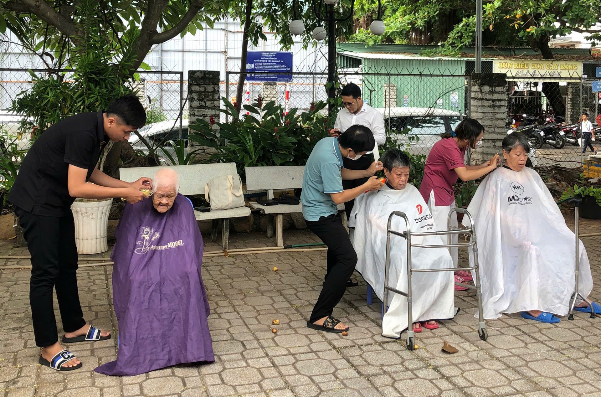 Nhân viên Salon tóc Calvin Tuấn Thành cắt tóc cho các cụ tại nhà dưỡng lão.