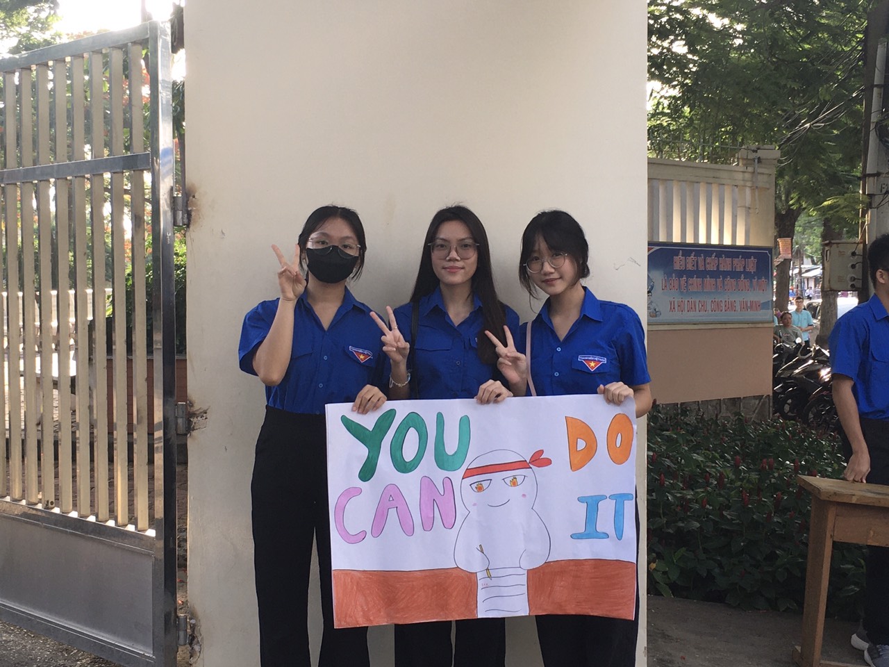 Đội tình nguyện viên động viên tinh thần thí sinh bằng pa - nô, khẩu hiệu.