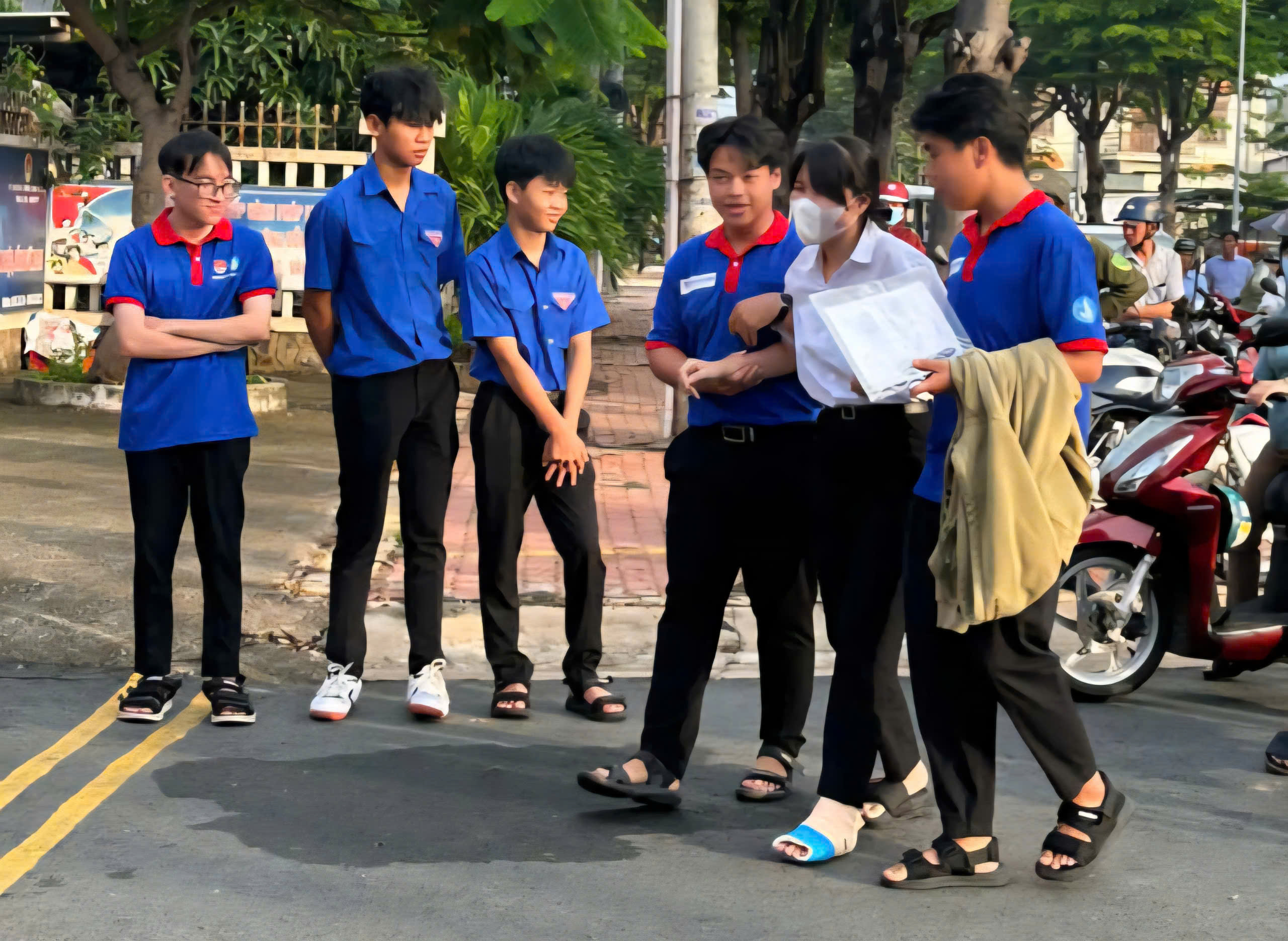 Tình nguyện viên tại điểm thi Trường THPT Phước Bửu (huyện Xuyên Mộc) hỗ trợ thí sinh bị chấn thương chân di chuyển vào phòng thi.