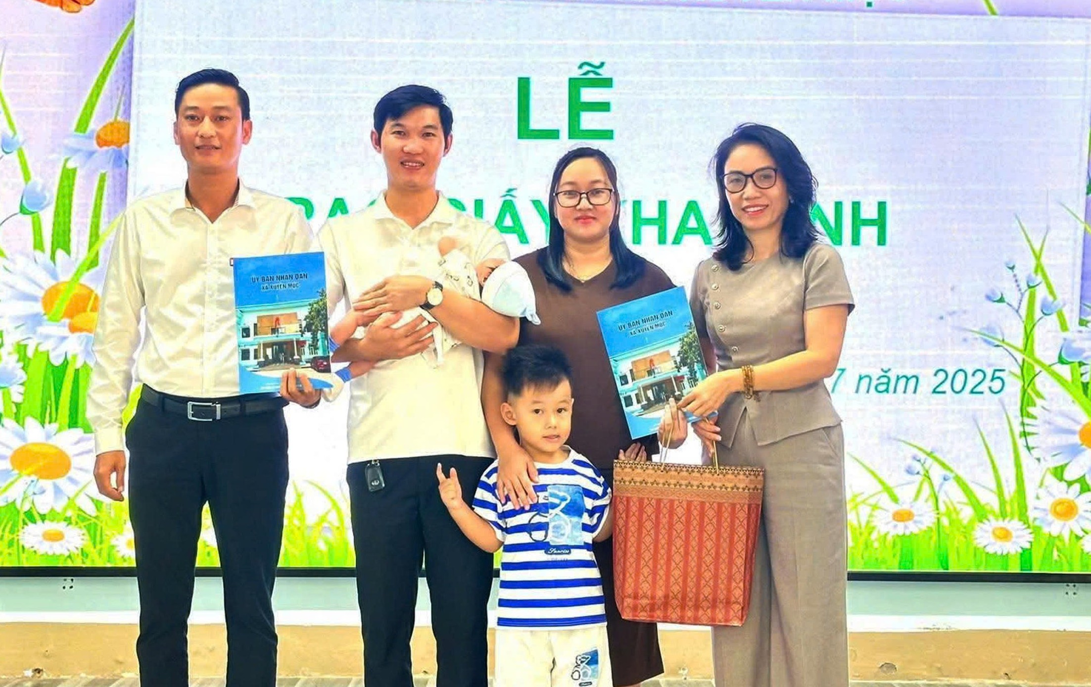 Đại diện UBND xã Xuyên Mộc trao giấy khai sinh và thư chúc mừng đến gia đình ông Trần Nhật Trung và bà Trần Thụy Tường Vy. Ảnh: NHÂN HỒNG